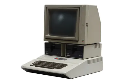 An original Apple II computer with monitor and disk drives.